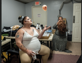 A woman sitting in a room with a balloon in her hand.