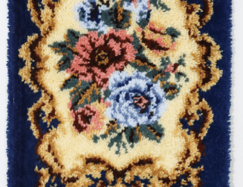 A blue wall hanging with tassels and flowers.