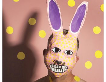 A man with bunny ears painted on his face.
