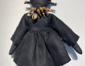 A black doll with a necklace and earrings.
